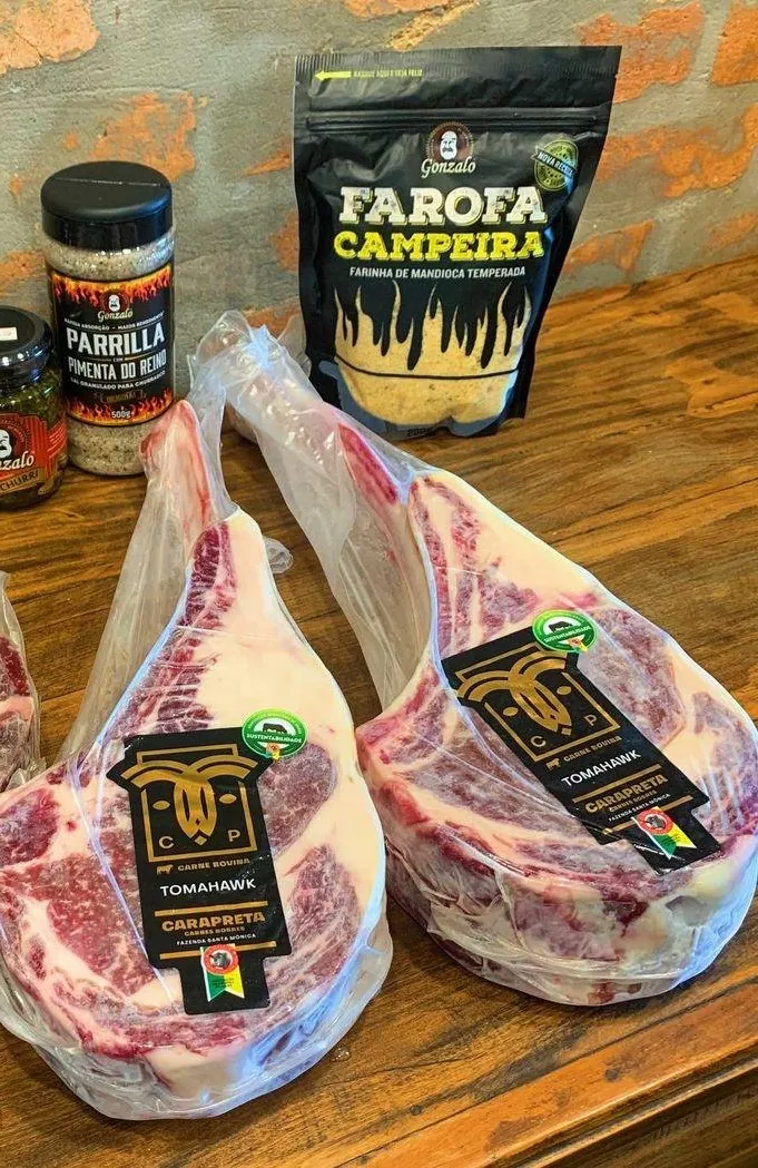 Tomahawks embalados no balcão ao lado de farofa campeira e temperos