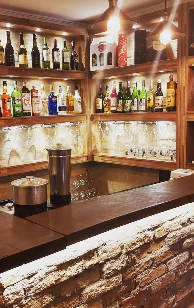 Bar da HB com prateleiras iluminadas de garrafas