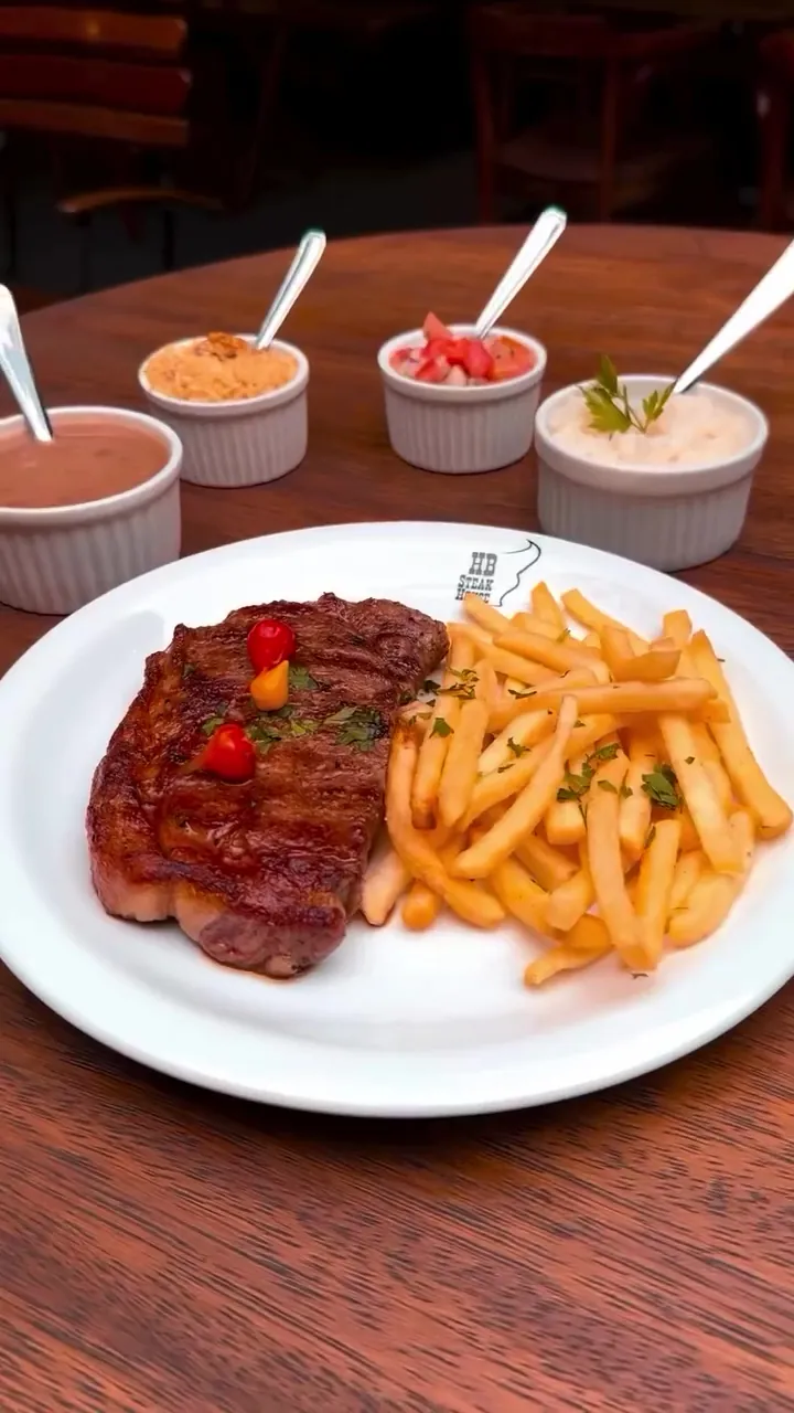 Bife grelhado com batatas fritas e três molhos